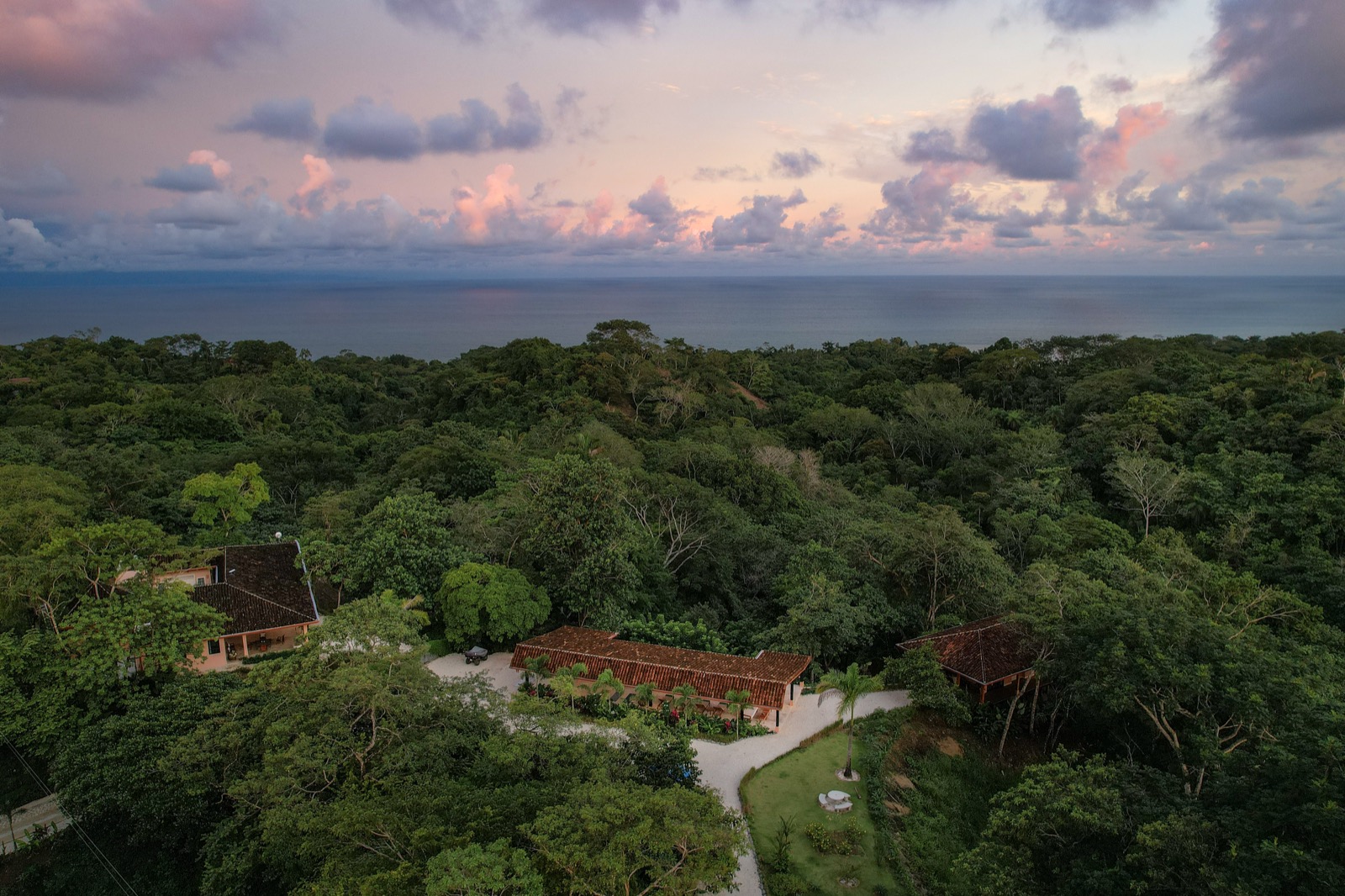 Aerial view of tropical estate at sunset with ocean