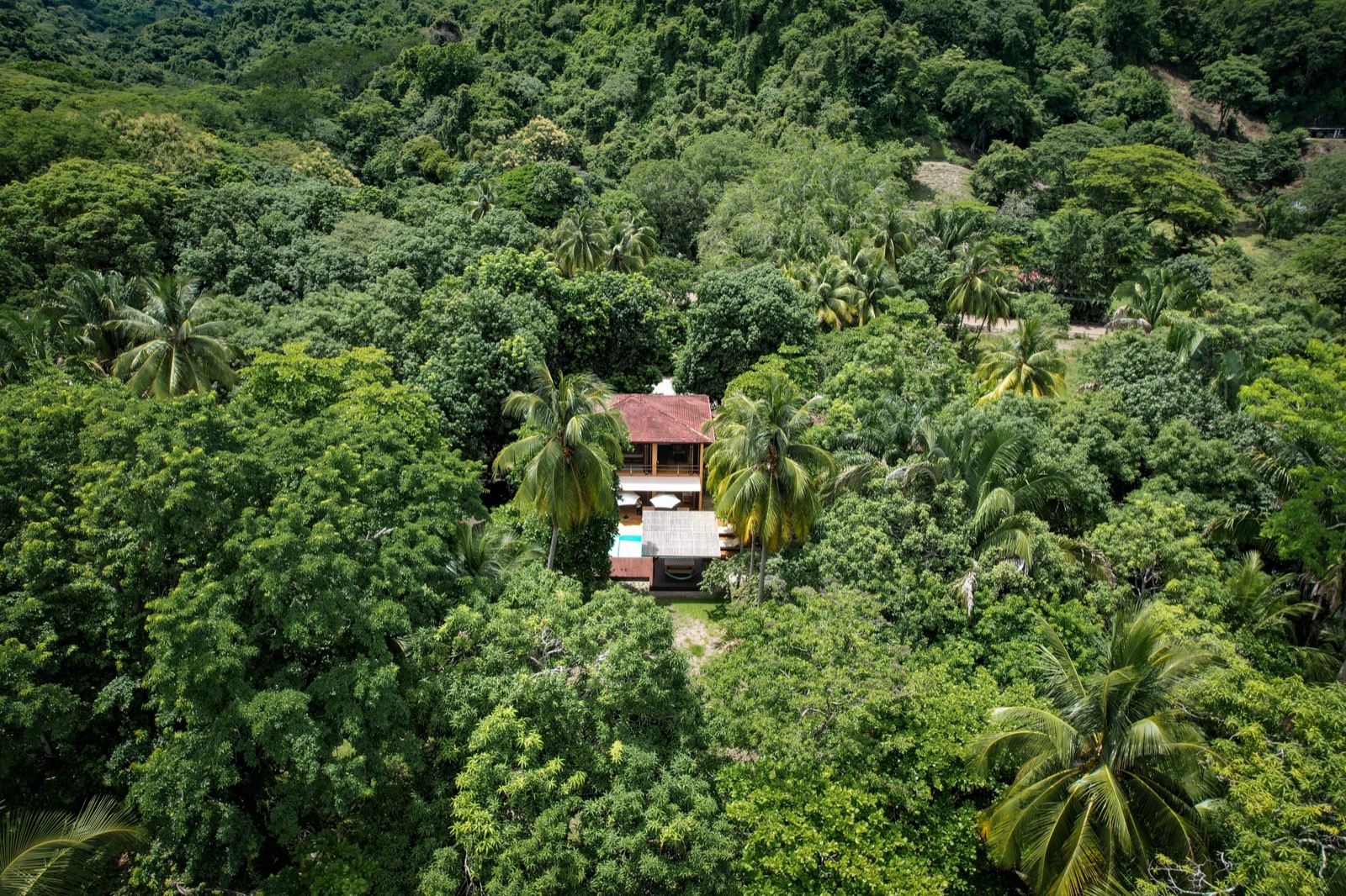 Aerial view of villa hidden in tropical jungle