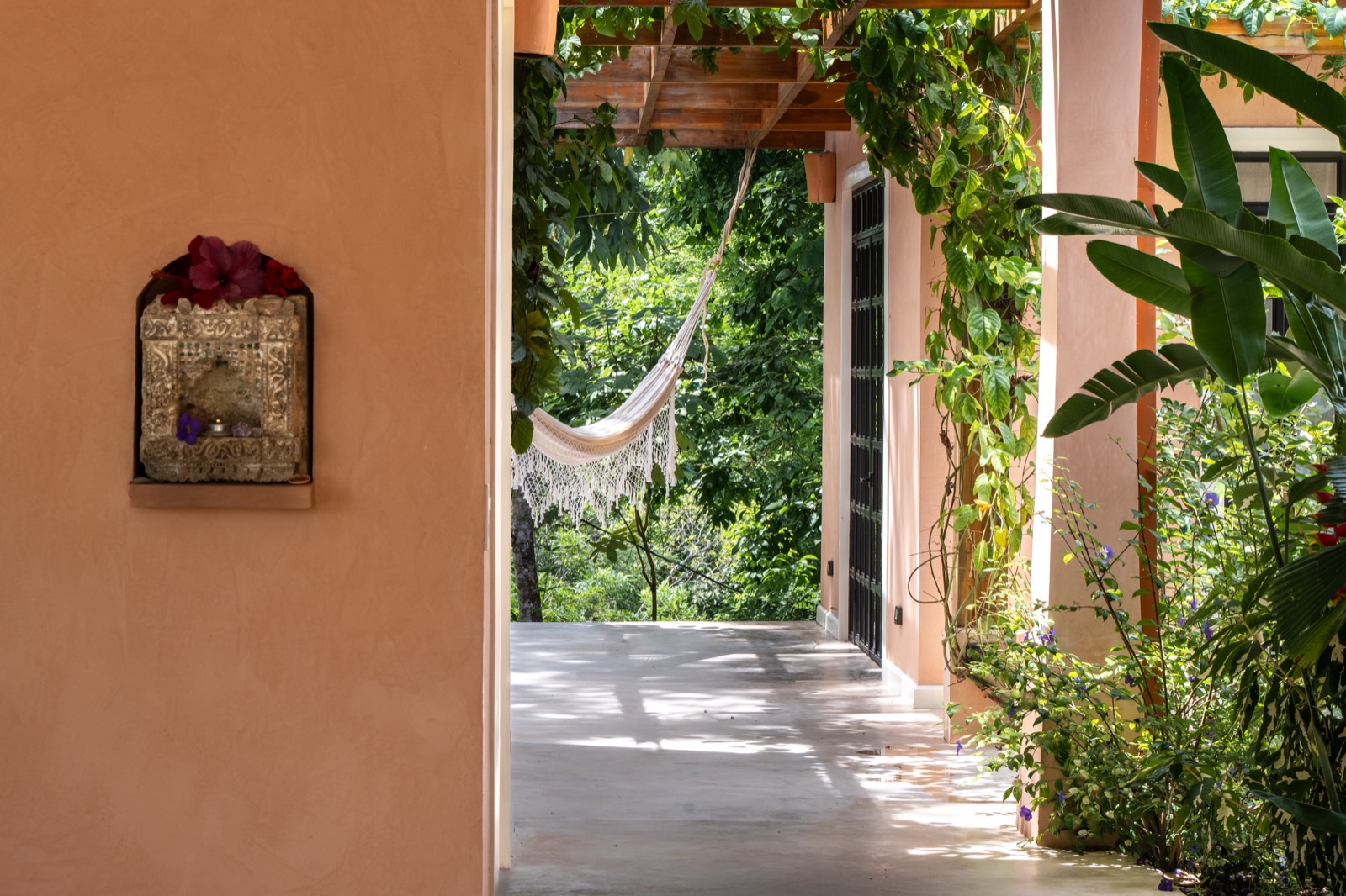 Pink terrace with white hammock and lush greenery